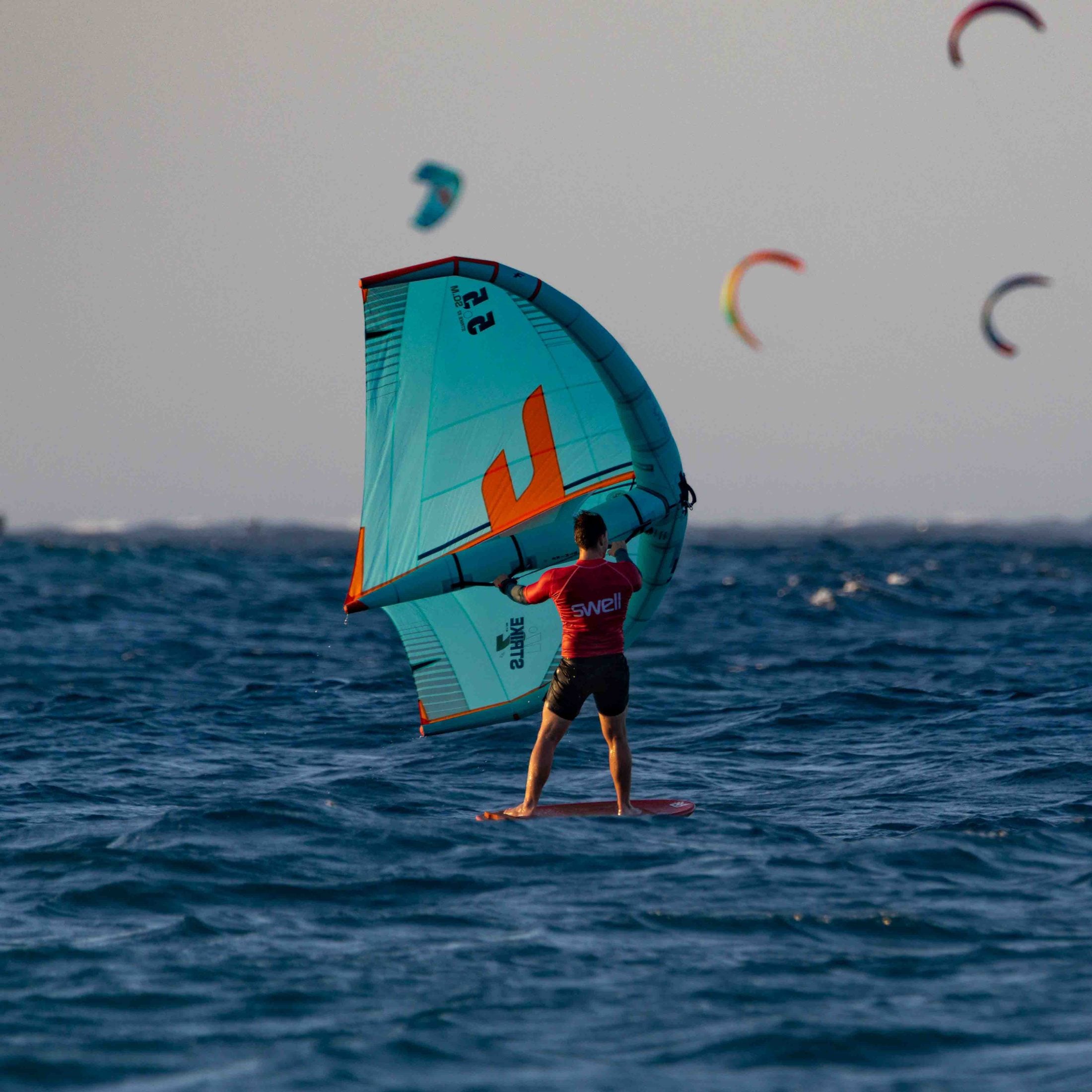 Wingfoiler riding across flat water